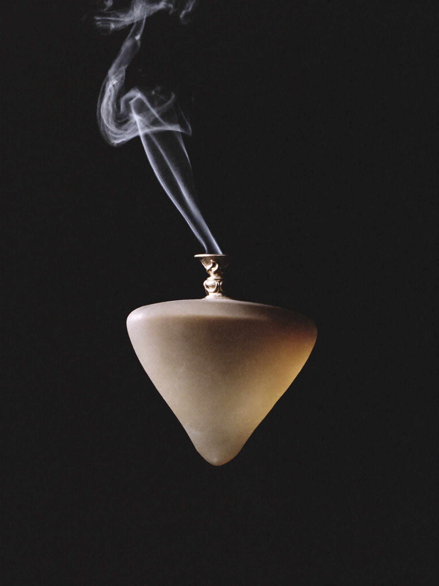 The SÉVE flacon, machined glass and platinum collar, catching cold studio light.
